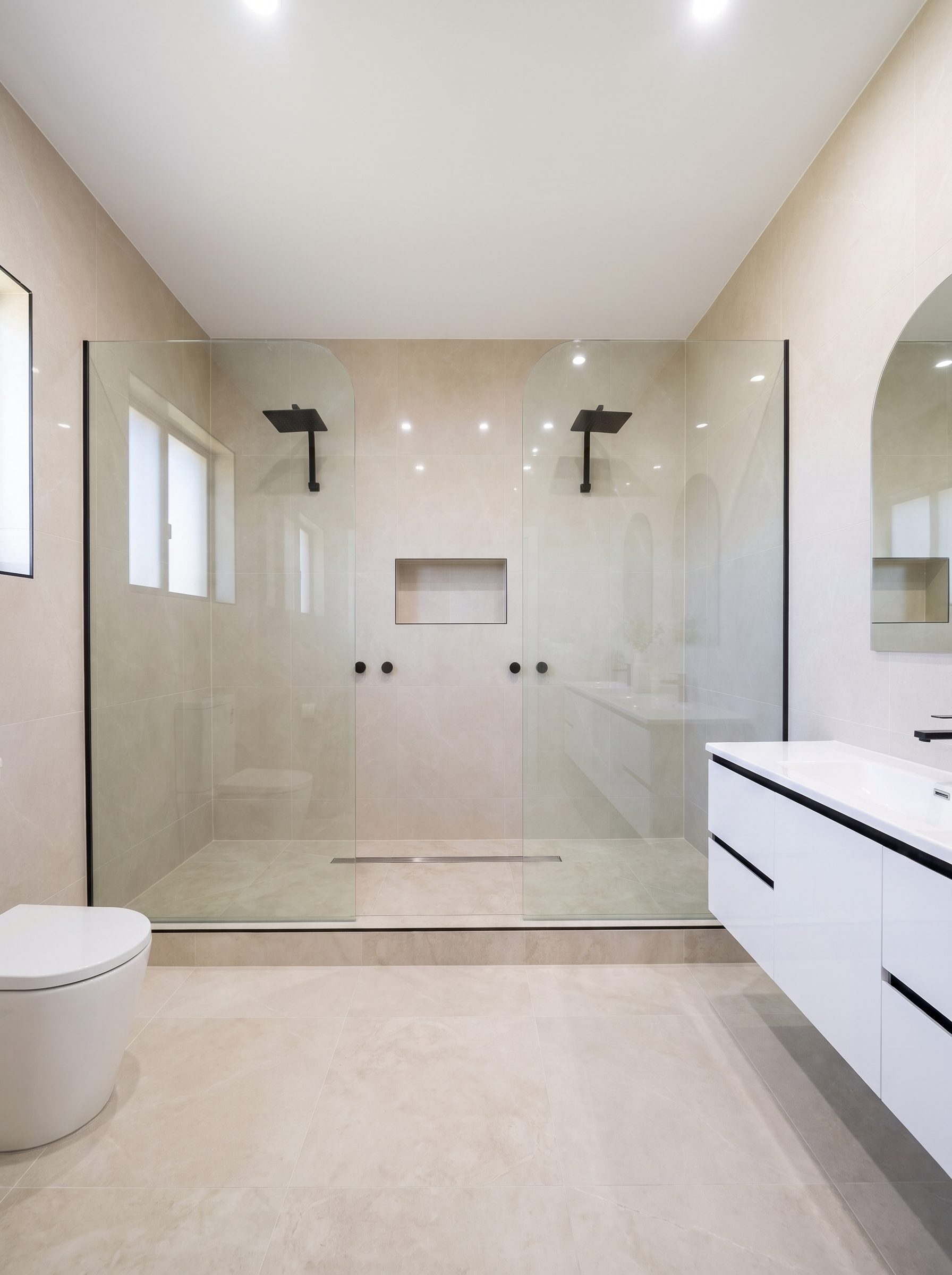 Frameless glass dual-shower ensuite bathroom tiled by Modern Tiling and Waterproofing